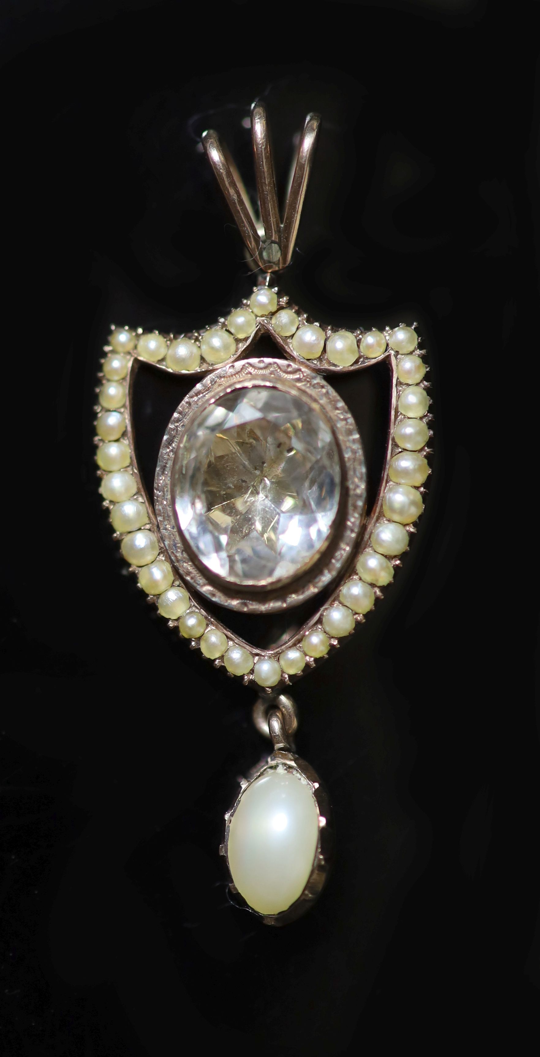 An early 19th century gold rock crystal, baroque and seed pearl set shield shaped drop pendant